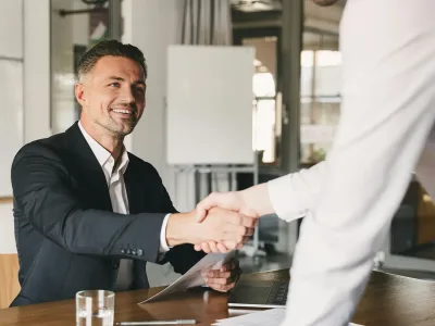 Shaking hands over successful deal in office showroom